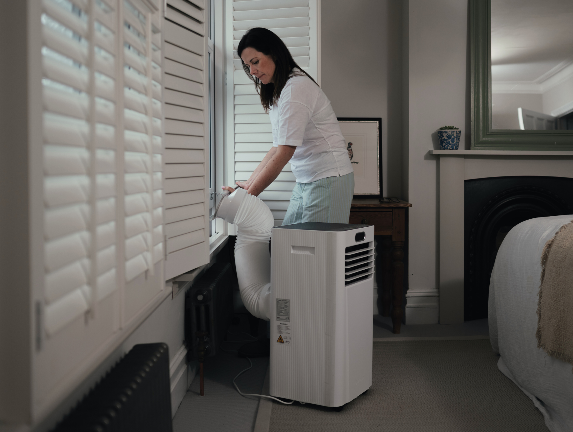 Woman installing MeacoCool window kit for an air conditioner
