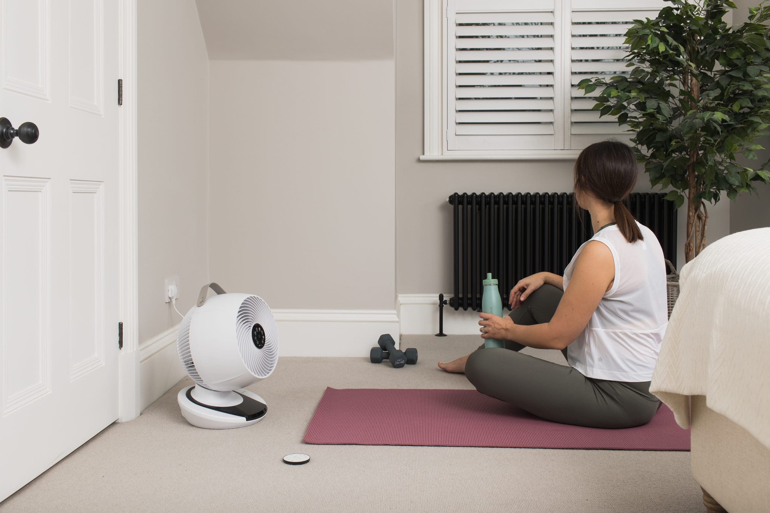 A lady keeping cool doing a workout with a fan