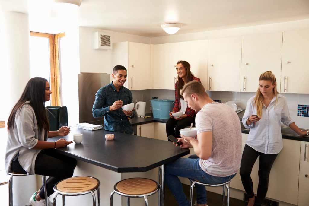 A group of students around a table in a shared kitchen