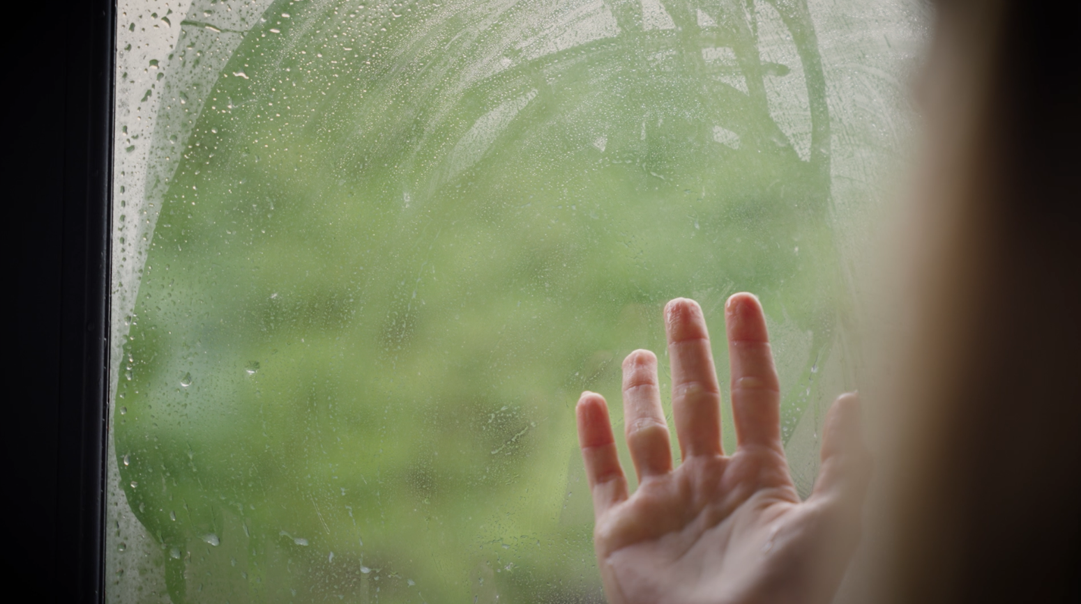 Hand wiping condensation off window